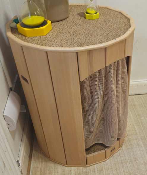 A wooden cosy nook with a soft mesh curtain, tucked into the corner of a nursery room