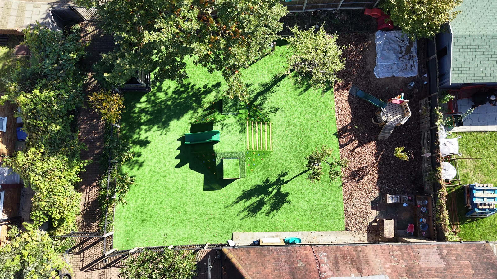 Aerial view of our garden showing the lawn, climbing mound, planting beds and mud kitchen area