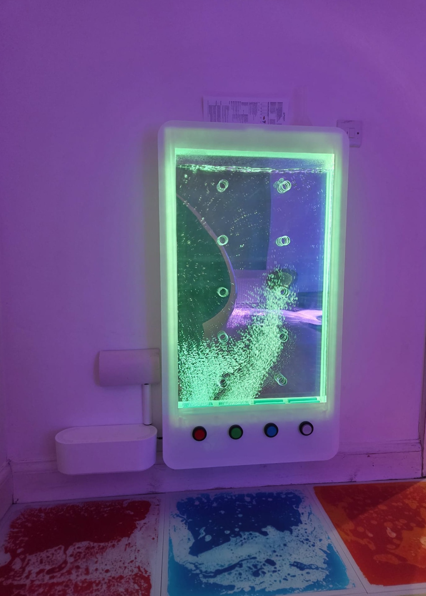 An interactive bubble wall with colour buttons children can press, above liquid sensory floor tiles